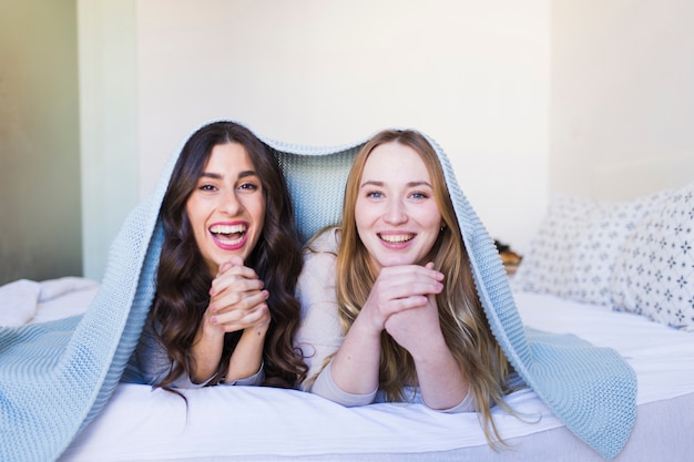 Free photo laughing women under blanket