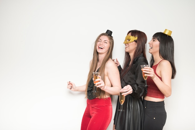 Laughing women in evening wear with glasses of drinks