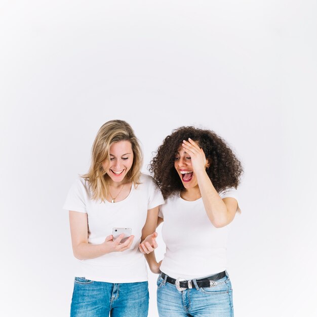 Laughing women using smartphone together