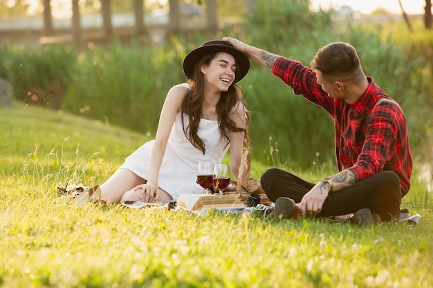 Laughting. Caucasian young, happy couple enjoying weekend together in the park on summer day