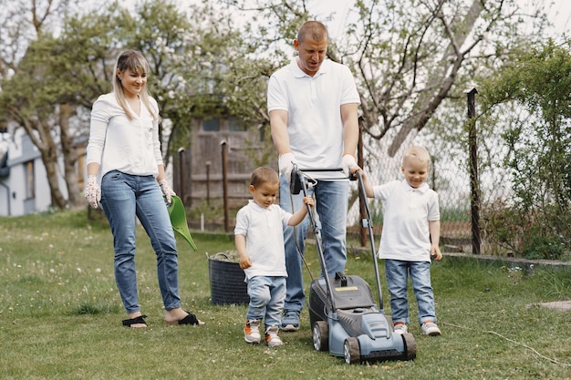 Lawn mower man working on the backyard with sons