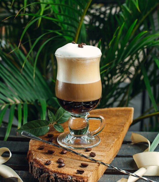 layered coffee with cream and coffee beans on rustic wood board