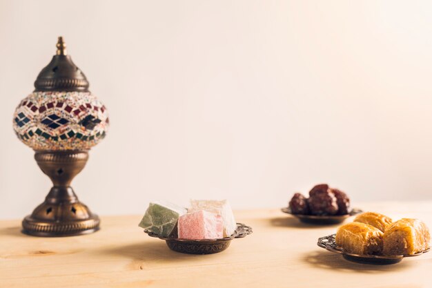 Layout of prunes near baklava and Turkish delights on saucers