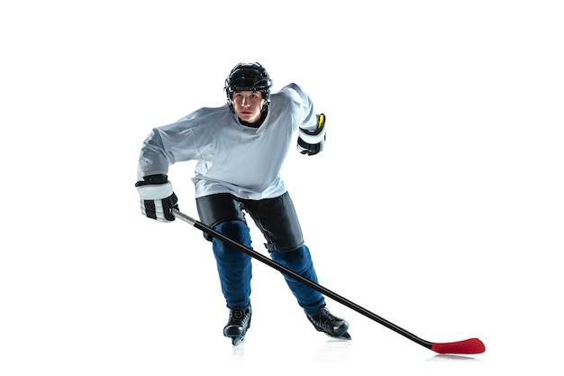 Leader. Young male hockey player with the stick on ice court and white background. Sportsman wearing equipment and helmet practicing. Concept of sport, healthy lifestyle, motion, movement, action.