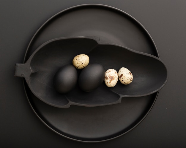 Free photo leaf shaped dark plate with eggs on a dark plate