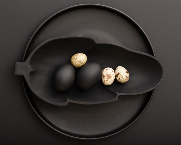 Free Photo leaf shaped dark plate with eggs on a dark plate