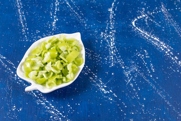 Free Photo leaf-shaped plate of sliced green bell peppers on marble surface. 