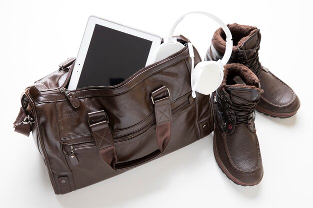 Leather bag packed with shoes and tablet