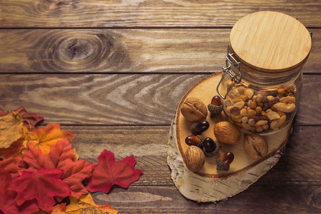 Free photo leaves near nuts and piece of wood