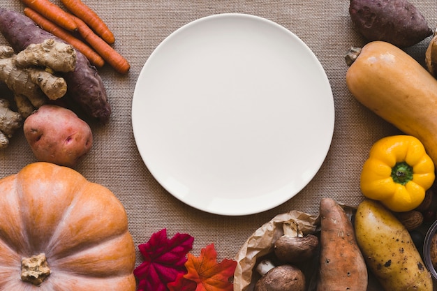 Free photo leaves and vegetables lying around plate