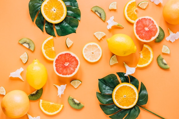 Free photo leaves with oranges near fruits and flowers