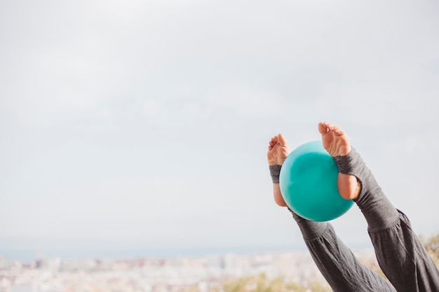 Leg view woman doing exercise with ball