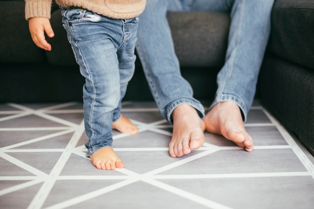 Free photo legs of sitting father and walking toddler