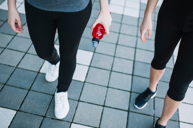 Free photo legs of sporty women with red drink