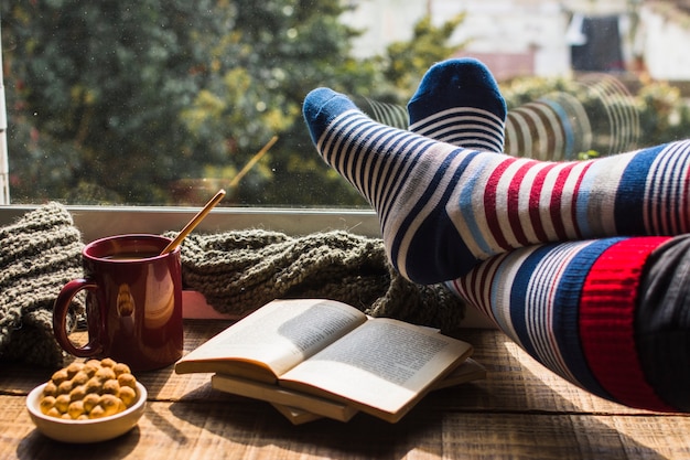 Legs in striped socks near window