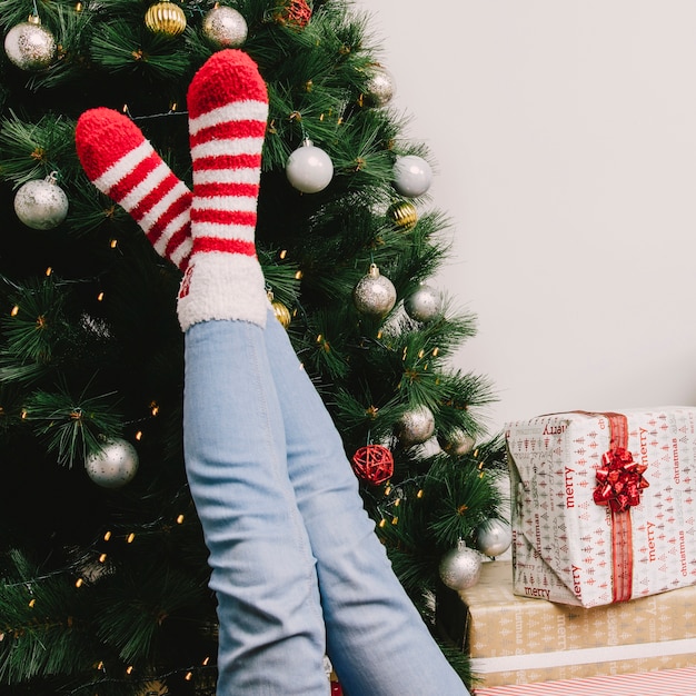 Free photo legs of woman in front of christmas tree