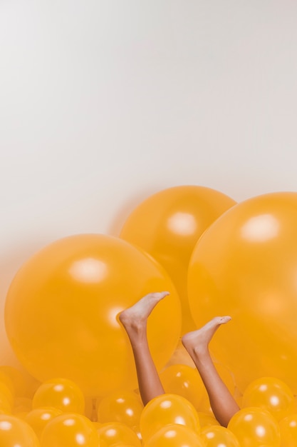 Free photo legs of woman between many yellow balloons