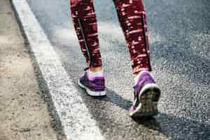 Free photo legs of woman running on road