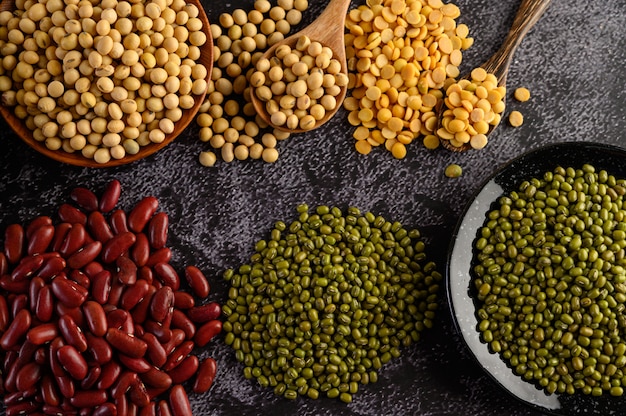 Legumes, and beans assortment on the black cement floor.