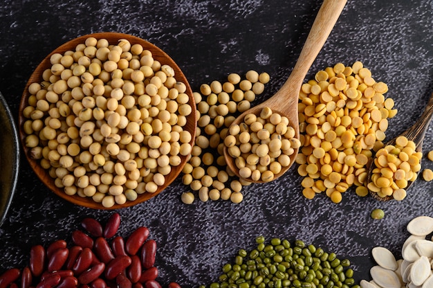 Legumes, and beans assortment on the black cement floor.