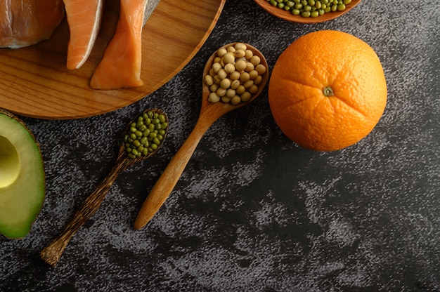 Free photo legumes, fruit and salmon pieces on a wooden plate.