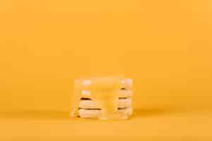 Free photo lemon curd dripping over stack of cookies on yellow backdrop