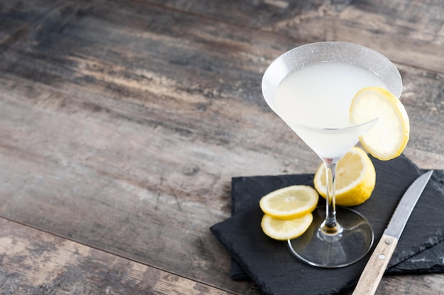 Lemon drop martini cocktail on gray stone and black background