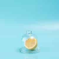 Free photo lemon in glass on blue background with copy space