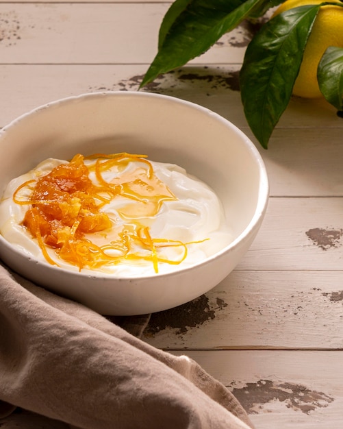 Lemon peel with yogurt and honey on wooden table