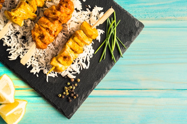 Free photo lemon and spices near board with chicken kebab