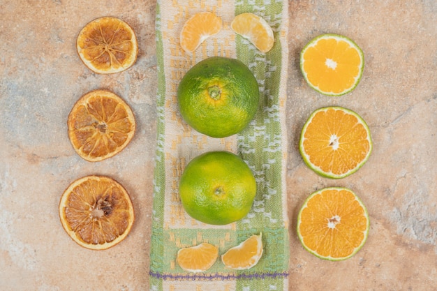 Free photo lemon, tangerine and orange slices on marble surface.