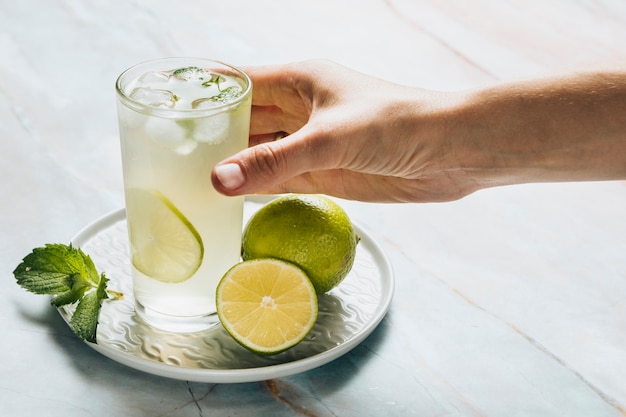 Lemonade glass and limes on bamble background