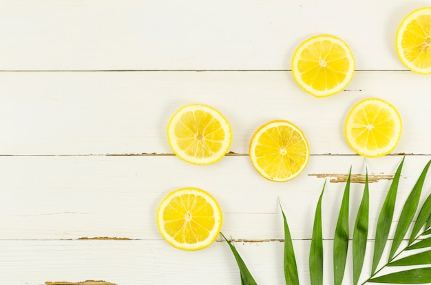 Free Photo lemons with palm leaf on table