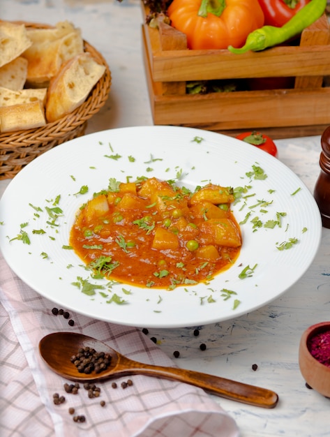 Lentil cream soup with potato and tomato sauce and vegetables , served with lavash in white plate