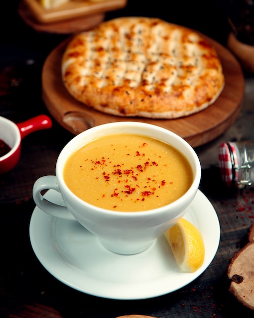 Lentil soup in a bowl for soups and a slice of lemon