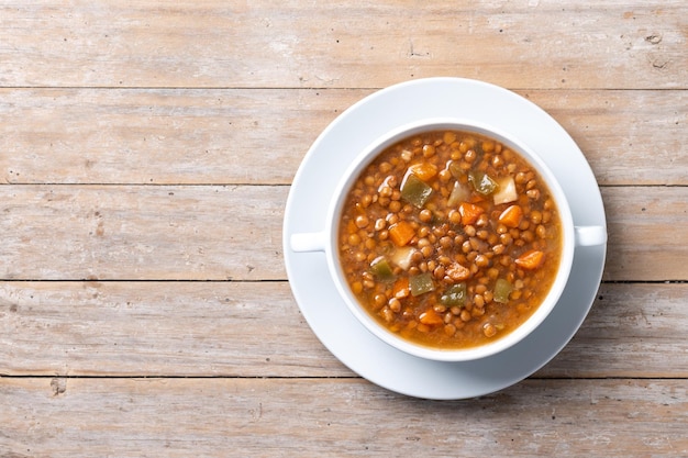 Free photo lentil soup with vegetables in bowl on wooden table