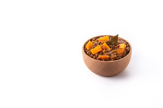 Lentil stew ragout with pumpkin and carrot in bowl isolated on white background