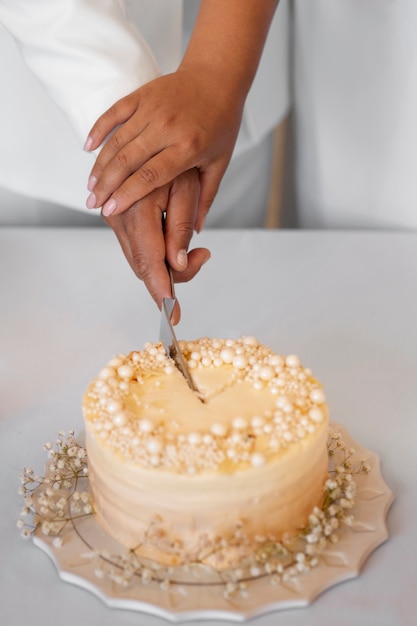 Free photo lesbian couple cutting the cake at their wedding