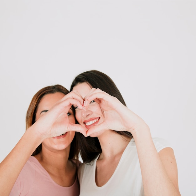 Lesbian couple gesturing heart