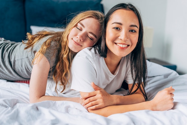 Lesbian couple lying on bed together