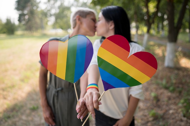 Free photo lesbian couple with lgbt heart shape flag