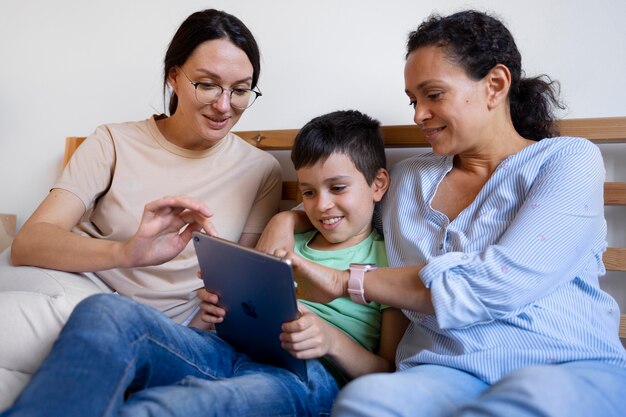 Lesbian couple with their son looking at a tablet