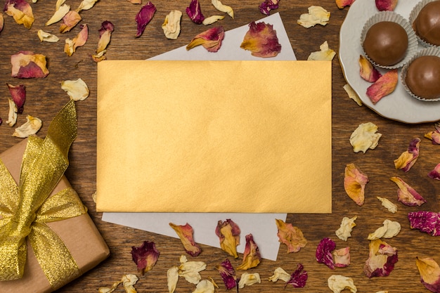 Free Photo letter near plate with candies and present box between dry leaves