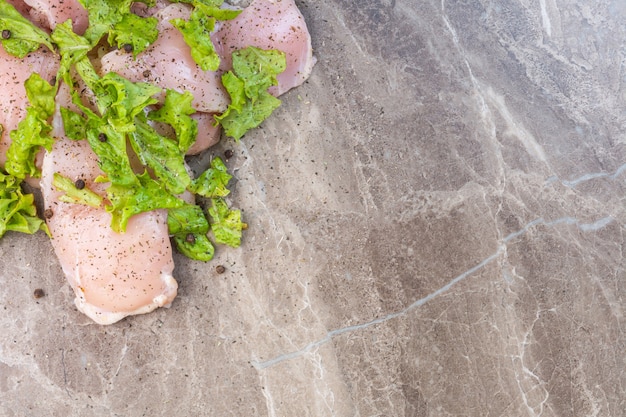 Lettuce and chicken meat, on the marble table.