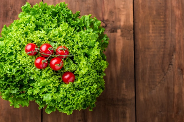 lettuce salad and cherry tomatoes on a wood wall