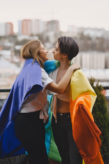 Free photo lgbt flag near girls. girls of non traditional orientation. hugs of lesbians.