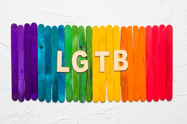 Free photo lgbt letters on background of colorful wooden sticks