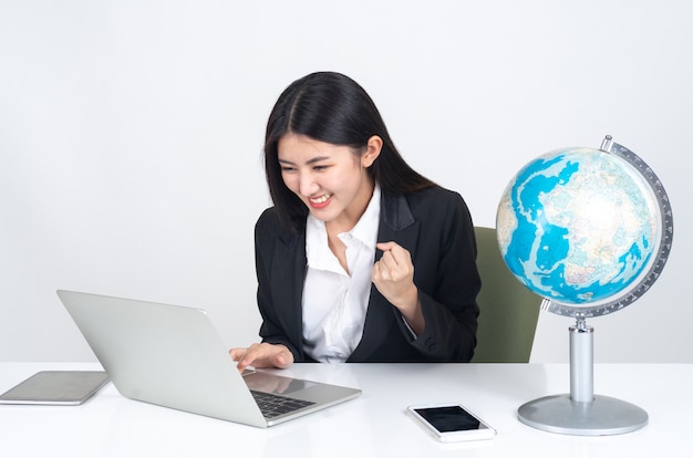 lifestyle beautiful Asian business young woman using laptop computer and smart phone on office desk