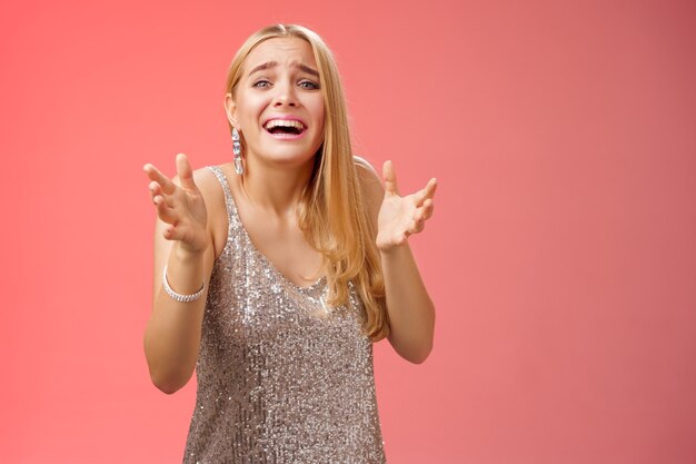 Lifestyle. Panicking upset miserable heartbroken blond girl crying raising hands begging not go broke-up boyfriend look sorrow distressed freak-out standing devastated red background during party.