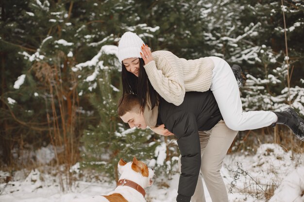 Lifestyle shot of couple in snowy forest with dog